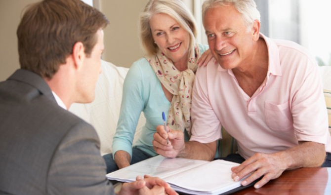 Senior Couple Meeting With Financial Advisor At Home